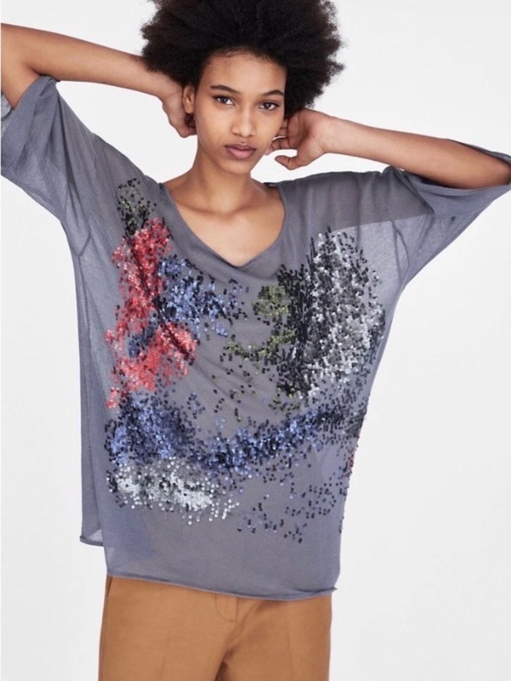 Oversized, semi-sheer, knit top with a round neckline and short sleeves.